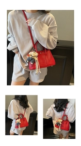 Détails de ce sac seau rouge en cuir grainé avec charm ours en peluche et clous en métal