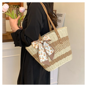 Close-up of contrast straw tote bag with silk scarf and leather handle on a female model