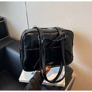 Detail shot of the glossy black patent leather bow on a stylish Korean style tote bag
