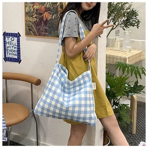 Detail of blue and white checkered canvas tote bag with spacious interior and wide strap