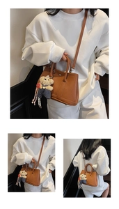 Détail d'un sac seau en cuir grainé marron avec charm ours en peluche et bandoulière