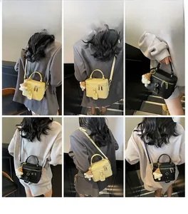 Detailed views of minimalist box bag in beige and black with cute sheep plush charm