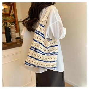 Detailed close-up of a handmade hollow crochet tote bag with navy blue stripes and texture
