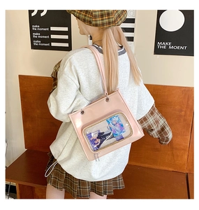 Pink ita bag with a clear PVC window and anime insert shown in a lifestyle setting