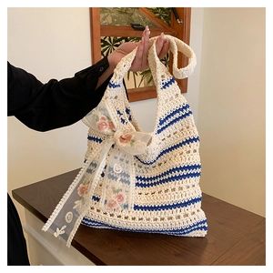 Detail of crochet knit tote bag with blue stripes and lace ribbon bow decoration