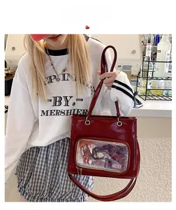Red oil wax leather tote bag with transparent PVC window shown in street style