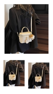 Macro detail of the creamy white grainy texture box bag with plush charm accessory