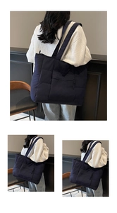 Détail macro du sac cabas matelassé bleu foncé avec motif rembourré et poche zippée