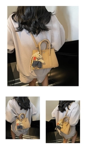 Sac seau marron clair à motif litchi avec pendentif ours et détail de foulard en soie
