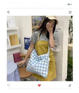 Blue and white checkered canvas tote bag with shoulder strap shown in a lifestyle setting