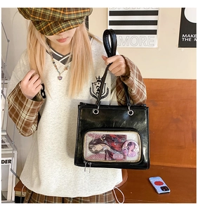 Detail of black ita bag with transparent window showing anime cards and badges