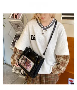 Detail of a chic black oil wax leather ita bag with transparent window for anime badges