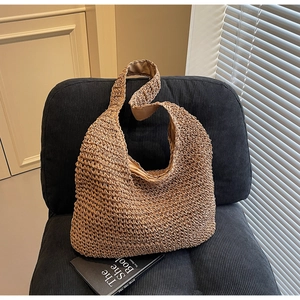 Detail of hand-woven straw tote bag with brown fabric lining on a designer chair