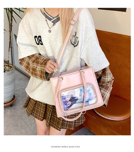 Detailed close-up of pink wax leather ita bag with clear PVC window and long shoulder strap