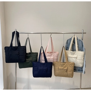 Détail de sacs fourre-tout matelassés en six couleurs avec texture et poche zippée