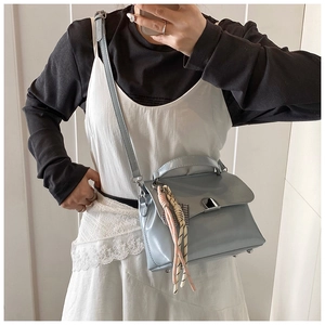 Detailed view of the light blue leather tote bag with silver buckle and woven ornament