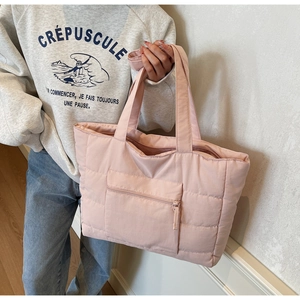 Détail du cabas matelassé rose avec poche zippée et texture en nylon souple