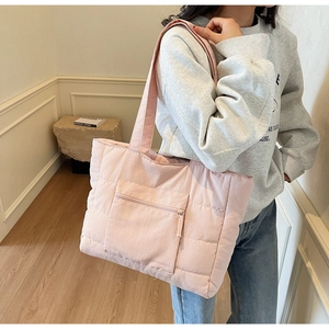 Gros plan du sac cabas matelassé rose avec poche zippée et texture en nylon léger