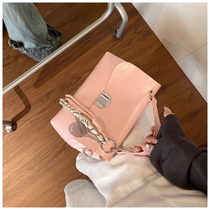 Pink faux leather tote bag detail with unique tennis racket charm and metal buckle clasp