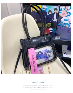 Detail of black ita bag featuring a large clear PVC window and smooth oil wax leather finish