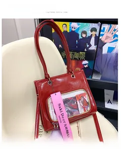 Detail of red wax leather ita bag featuring a clear transparent window and shoulder strap