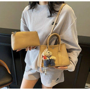 Détail du cabas en cuir à motif litchi et pochette zippée avec pendentif ours