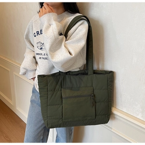 Détail du sac cabas matelassé vert foncé avec poche zippée et texture rembourrée