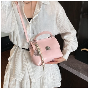 Detail view of pink soft leather tote bag with silver buckle and woven strap ornament