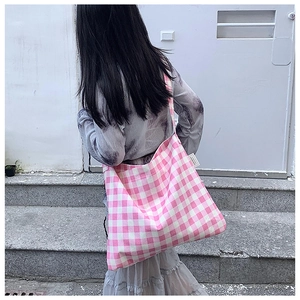 Detail of pink and white checkered tote bag showing soft cotton texture and woven label