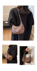 Detail view of a dark brown crescent hobo bag with adjustable strap and gold hardware
