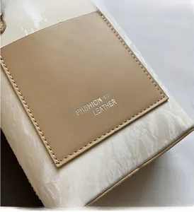 Detail of marble pattern handbag featuring a leather patch with embossed text