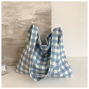 Close-up of blue and white checkered canvas tote bag with woven texture and side tag