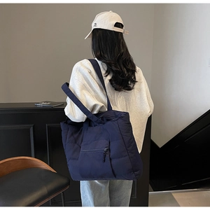 Détail du grand sac cabas matelassé bleu marine avec texture rembourrée et poche zippée