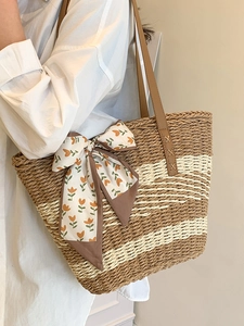 Chic woven straw tote bag with brown stripes and floral silk scarf for summer beach vacation