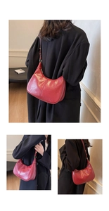 Detail view of retro red underarm bag with glossy oil wax leather and golden buckles