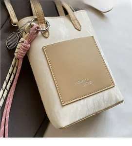 Detailed close-up of marble pattern crossbody bag with leather pocket and woven strap