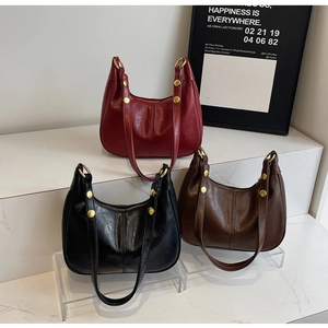 Detail of the vintage hobo bags showing polished leather and gold rivet hardware