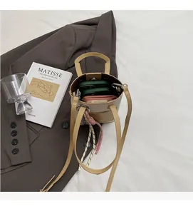 Spacious interior of a brown bucket bag showing room for a phone and long zipper wallet