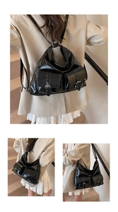 Detail of black patent leather tote bag with silver buckles and dual-strap backpack function