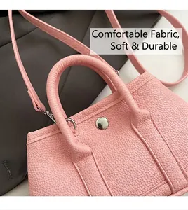 Detalle de cuero granulado rosa con hebilla metálica y correa de hombro desmontable