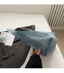 Dettaglio delle cuciture di qualità sulla borsa tote in denim con riflessi stellati