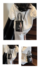 Detail of black leather crossbody bag with decorative rope knot and fashion lettering