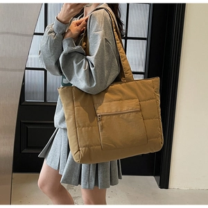 Détail d'un grand sac fourre-tout matelassé jaune avec coutures et poche zippée