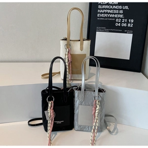 Minimalist crossbody bags in black, silver and beige displayed on a white tiered stand