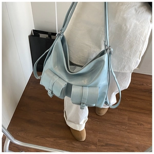 Detail of light blue PU leather tote bag featuring functional front pockets and silver buckles