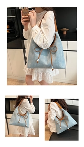 Dettagli della borsa tote in denim azzurro con fiocco marrone e manici in finta pelle