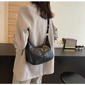 Detail of a vintage black hobo bag with soft leather texture and golden hardware
