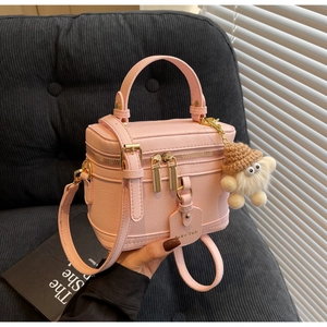 Close-up of pink box handbag with lychee texture and cute lamb keychain detail