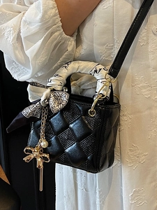 Black quilted mini handbag with scarf-wrapped handle and elegant pearl charm detail