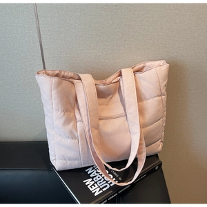Vue détaillée du sac cabas matelassé rose clair avec poche zippée et bandoulière souple